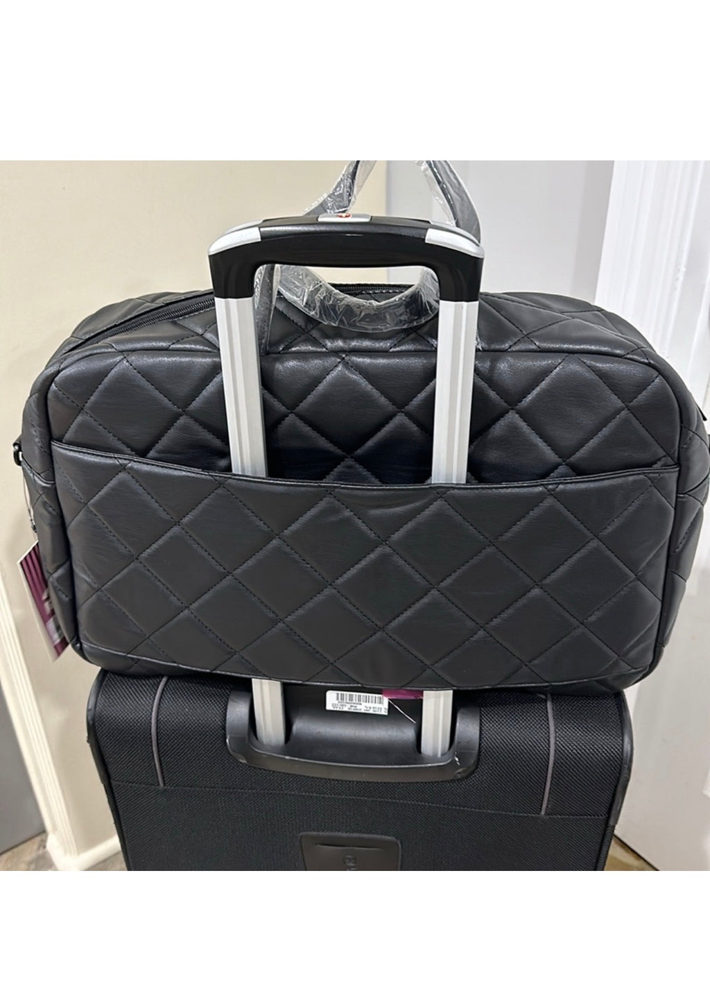 Gilda Paris black quilted weekender attached to luggage handle