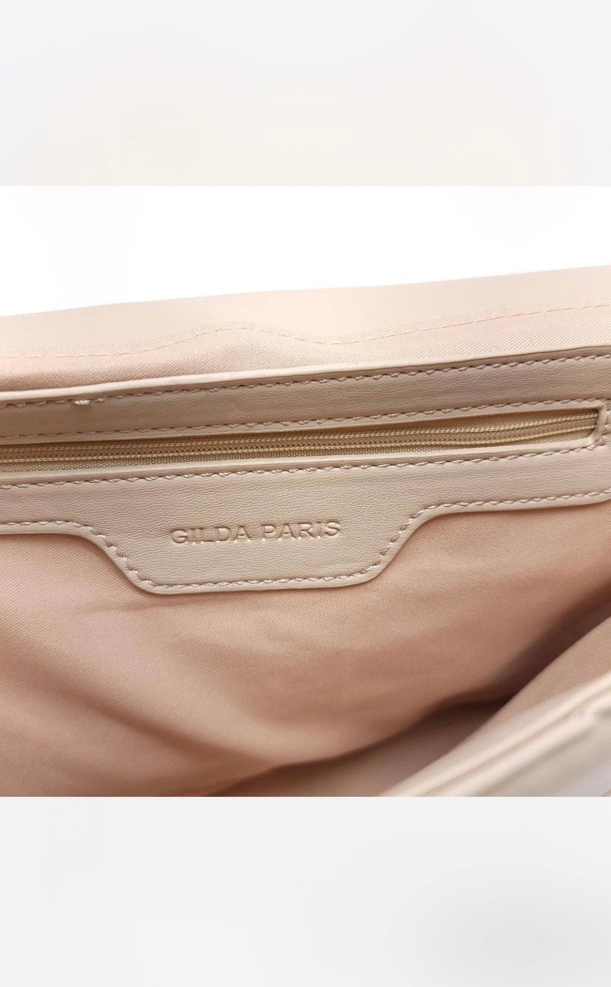 Interior label and zip pocket of Gilda Paris bone crossbody
